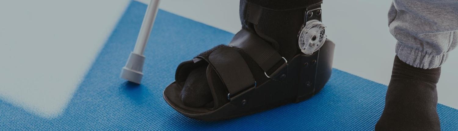 Patient in a black leg brace in a physiotherapy office